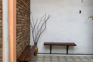 a bench sitting next to a wall with a vase at KoolKost near Budi Mulia Siantar in Pematangsiantar