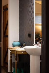 uma casa de banho com um lavatório e um espelho em Piccolo Cosy Cottage with views em Hepburn