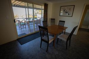 a dining room with a table and chairs and a balcony at Park View, Maitland in Maitland