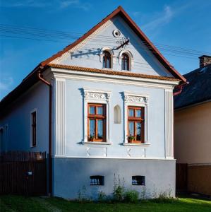 Casa blanca con 2 ventanas y valla en Hybský dom en Hyby