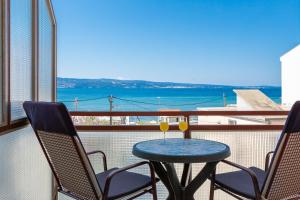 una mesa y sillas en un balcón con vistas al océano en Beach Apartments Croatia, en Duće