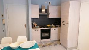 a kitchen with white cabinets and a stove top oven at Stella Marina in Principina a Mare