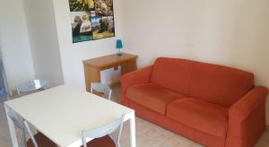 een woonkamer met een bank en een tafel bij Villa piscina 24 posti letto in Torre dell'Orso