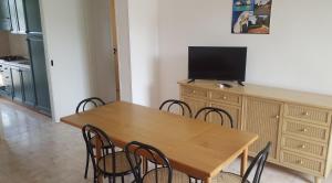 een eetkamer met een houten tafel en stoelen bij Villa piscina 24 posti letto in Torre dell'Orso