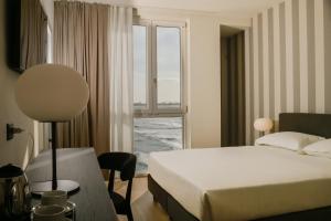 a hotel room with a bed and a window at Hotel Punta Tipa in Trapani