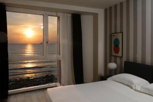 sypialnia z oknem z widokiem na ocean w obiekcie Hotel Punta Tipa w Trapani