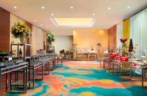 a banquet hall with tables and chairs on a colorful carpet at Hotel Ciputra Jakarta in Jakarta