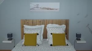 a bedroom with a bed with two pillows at A L Ancre de la Rive in Le Faou