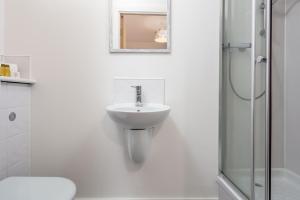 a white bathroom with a sink and a shower at Walker Suite No73 - Donnini Apartments in Kilmarnock