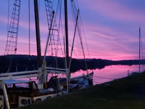 a boat docked at a dock with a sunset at A L Ancre de la Rive in Le Faou