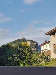 un castillo en la cima de una colina con árboles en Casa Vacanze Calzà en Arco