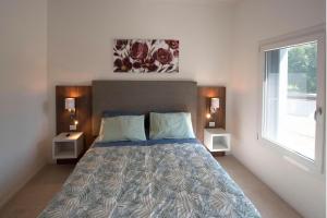 ein Schlafzimmer mit einem Bett mit zwei Nachttischen und einem Fenster in der Unterkunft Residence Le Querce in Cordovado