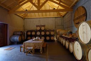 una habitación con una mesa y un montón de barriles de vino en Quinta da Casa Amarela- Casas da Quinta - Turismo em Espaço Rural, en Lamego