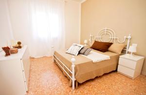 a white bedroom with a bed and a window at Apt luminoso, spazioso con Aria condiz e bici in Viareggio