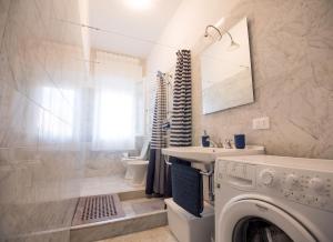 a bathroom with a washing machine and a sink at Apt luminoso, spazioso con Aria condiz e bici in Viareggio