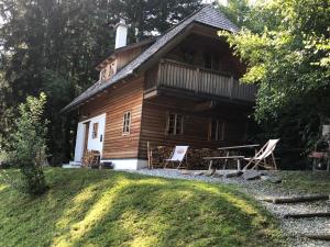 uma cabana de madeira com duas cadeiras de jardim em frente em Brandluckner Nesterl em Heilbrunn