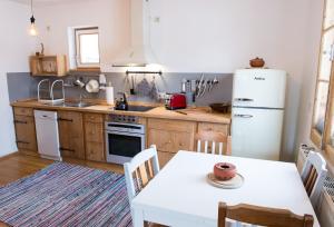 eine Küche mit einem Tisch und einem weißen Kühlschrank in der Unterkunft Retro Apartment Kitzbühel in Kitzbühel