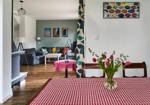 een woonkamer met een tafel met een vaas met bloemen erop bij Pod Lasem in Ludwinów