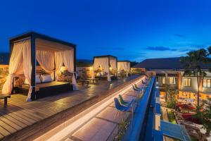 una terraza del hotel con camas y sillas por la noche en Padmasari Resort Lovina, en Lovina