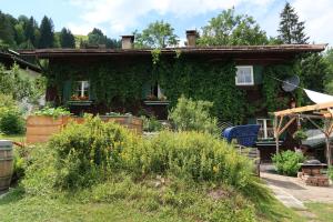 una casa cubierta de hiedra delante de un patio en Retro Apartment Kitzbühel en Kitzbühel