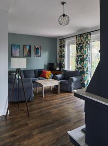 a living room with a couch and a table at Pod Lasem in Ludwinów