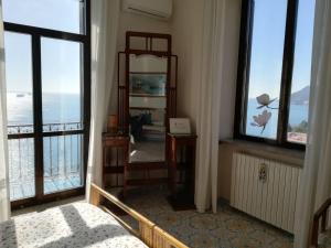 a bedroom with a view of the ocean from a balcony at Lady Ida B&B in Vietri sul Mare