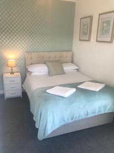 a bedroom with a bed with two towels on it at Rooms at The Highcliffe in Aberporth