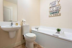 a bathroom with a toilet and a sink and a tub at Elliot Suite No15 - Donnini Apartments in Ayr