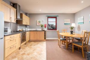a kitchen with a table and a dining room at Elliot Suite No15 - Donnini Apartments in Ayr