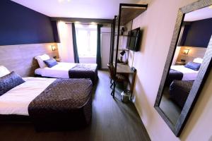 Habitación de hotel con 2 camas y espejo en Tasty World en Hoogerheide