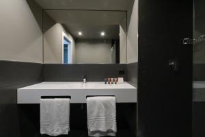 a bathroom with a white sink and a mirror at Hotel Punta Tipa in Trapani