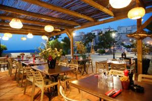 a restaurant with tables and chairs and a view of the ocean at Hotel Restaurant Christophe Colomb in Calvi