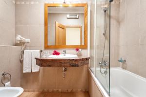 a bathroom with a sink and a tub and a mirror at Pestana Palm Gardens in Carvoeiro