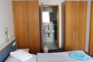 ein Schlafzimmer mit einem Bett und ein Badezimmer mit einem Waschbecken in der Unterkunft Gästehaus Germania in Wangerooge