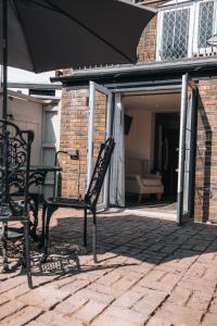 a patio with an umbrella and a table and chairs at Riverbank Cottage in Ironbridge