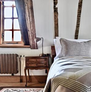 ein Schlafzimmer mit einem Bett und einem Tisch mit einer Lampe in der Unterkunft Lainston House in Winchester