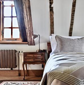 a bedroom with a bed and a table with a lamp at Lainston House in Winchester