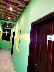 une chambre avec une porte munie d'un panneau. dans l'établissement LE MILAN ( appartements et chambres meublés ), à Douala