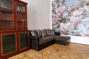 a leather chair in a room with a painting of flowers at Апартаменты у Невского проспекта in Saint Petersburg
