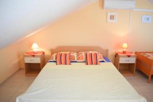 een slaapkamer met een bed met twee lampen op twee tafels bij Apartments Pine Diver in Pinezici