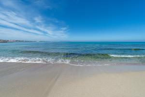 a sandy beach with the ocean in the background at Hotel Punta Tipa in Trapani