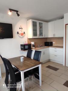 a kitchen with a table and chairs and a microwave at Vier Jahreszeiten Haus 3 Whg 24 in Großenbrode