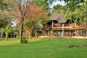 a resort building with trees and green grass at Cresta Mowana Safari Resort & Spa in Kasane