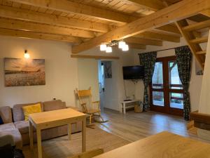 a living room with a couch and a table at Wooden House&Pool in Osowa