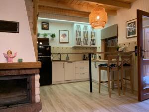 a kitchen with a fireplace and a table and a stove at Wooden House&Pool in Osowa