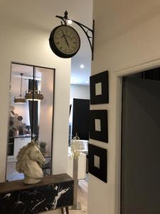 un reloj colgando en una pared junto a un espejo en Suite Darcy & Spa, en Dijon