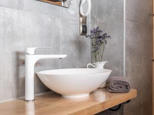 a bathroom with a white bowl sink and a vase of flowers at Wierchowa Chata in Kościelisko