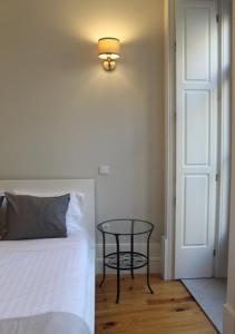 1 dormitorio con 1 cama y 1 mesa junto a la puerta en Oporto Coliseum Studio, en Oporto