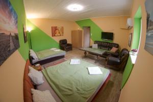 a room with two beds and a living room with a couch at Müller's 2 in Siófok