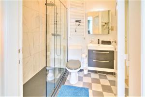 a bathroom with a toilet and a glass shower at Penth A Apartment in Heart of Antwerp in Antwerp